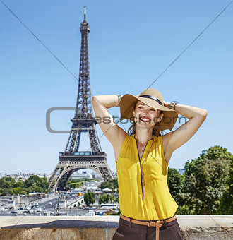 relaxed woman in bright blouse in front of Eiffel tower in Paris