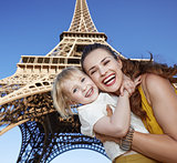 smiling mother and child tourists against Eiffel tower in Paris