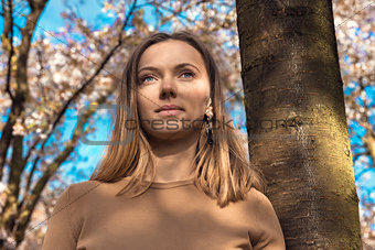 Beautiful happy young woman enjoying smell in a flowering spring