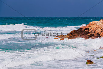 Seascape with a lot of foam, waves and stone heaps