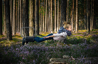 Beautiful blond girl levitates in the forest.