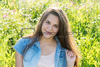 15 year girl with long brown hair on summer glade