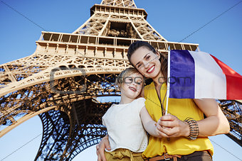 mother and child tourists showing flag near Eiffel tower, Paris