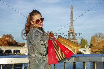Happy elegant woman with shopping bags near Eiffel tower, Paris