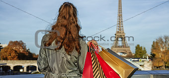 Elegant woman with shopping bags looking on Eiffel tower, Paris
