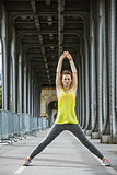 sportswoman stretching on Pont de Bir-Hakeim bridge in Paris