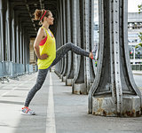 sportswoman stretching on Pont de Bir-Hakeim bridge in Paris