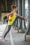 woman jogger stretching on Pont de Bir-Hakeim bridge in Paris