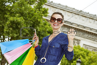 Woman with shopping bags handwaving in Paris, France