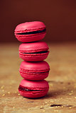 red macarons on a rustic wooden surface
