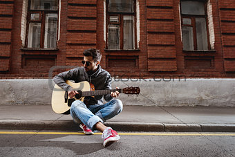 Man plays on guitar at the street