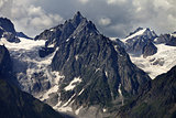 Mountains with glacier in clouds before rain