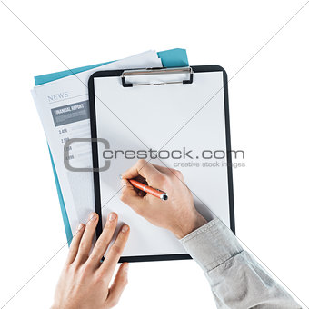 Businessman writing down notes on a clipboard