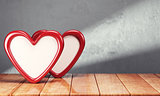 Two hearts on wooden table over gray background