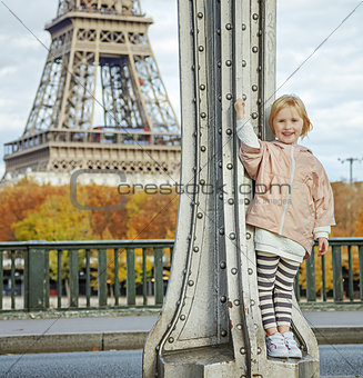 happy child in sport style clothes against Eiffel tower in Paris