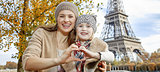mother and daughter tourists in Paris showing heart shaped hands