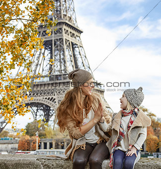 mother and child travelers playing on embankment in Paris