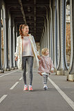 active mother and child on Pont de Bir-Hakeim bridge walking