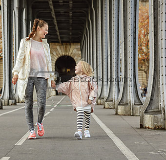 healthy mother and child on Pont de Bir-Hakeim bridge walking