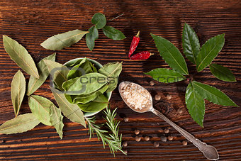 Spice and condiments wooden background.