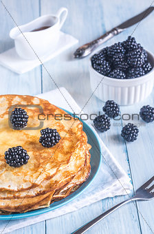 Crepes with blackberries on the wooden table