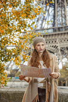 young tourist woman on embankment in Paris, France with map