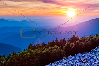 Colorful sunset sunshine clouds and above blue mountains