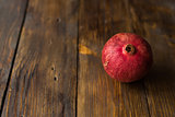 Red and ripe pomegranate lying on the wooden background