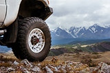 Big car wheel on background of mountains