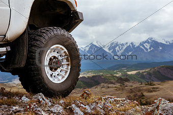 Big car wheel on background of mountains