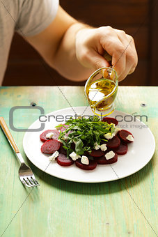chef prepares salad of boiled beets, cheese and arugula