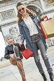 happy mother and child shopper near Arc de Triomphe going forwar