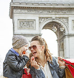 happy mother and daughter in Paris, France eating macaroons
