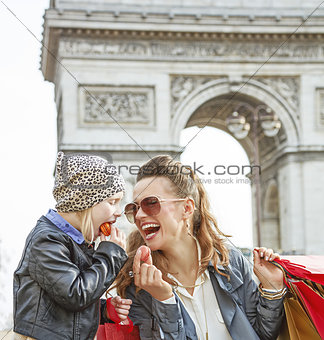 happy mother and daughter in Paris, France eating macaroons