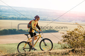 Mountain Bike cyclist riding single track above sunset valley