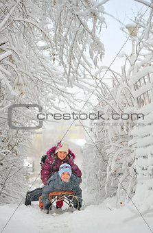 Two cute kids riding sled 