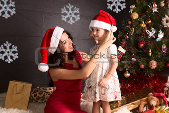 Happy mother and small girl with Christmas decoration around