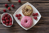 Ripe tasty raspberries and donuts on wooden background.Selective