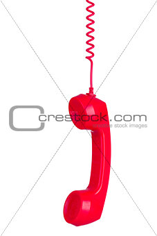 Red phone headset hanging by its wire isolated on white backgrou