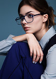 Businesswoman portrait with glasses and blue suit with hand under the chin