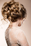 Beautiful bride with fashion wedding hairstyle - on beige background.