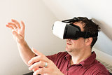 Man resting on sofa wearing VR headset glasses