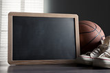 Blackboard with canvas shoes and basketball