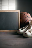 Blackboard with canvas shoes and basketball
