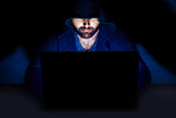 Man working at computer in dark room