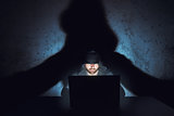 Man hacker works in dark empty room
