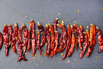 Dried red chili peppers on slate background. Copy space Top view