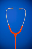 Orange stethoscope headset closeup isolated on blue background