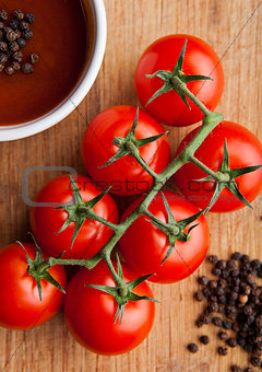 Fresh tomatoes with sause and spoon with pepper kitchen board