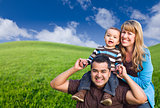 Mixed Race Family In Green Grass Field